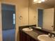 Bathroom with double sinks and dark wood cabinets with view to another room at 3108 Broadleaf Trl, Fairburn, GA 30213