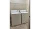Functional laundry room featuring a washer, dryer, and wire shelving for organized storage at 3108 Broadleaf Trl, Fairburn, GA 30213