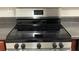Close up of a stainless steel and black top stove with black knobs and countertops at 3108 Broadleaf Trl, Fairburn, GA 30213