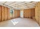 Unfinished basement area with exposed framing, window, door, and visible insulation in the ceiling at 682 Shelton Sw Ave, Atlanta, GA 30310