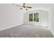 Bright bedroom with a large window showcasing nature and soft gray carpet flooring at 682 Shelton Sw Ave, Atlanta, GA 30310