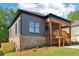 Back view of the house featuring wood porch and gray siding with black trim, with a brick foundation at 682 Shelton Sw Ave, Atlanta, GA 30310