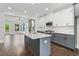 Contemporary kitchen with stone fireplace, gray cabinets, stainless steel appliances, and island at 682 Shelton Sw Ave, Atlanta, GA 30310