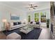 Bright living room with a stone fireplace, ceiling fan, and large windows overlooking the yard at 682 Shelton Sw Ave, Atlanta, GA 30310