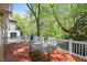 Spacious wooden deck perfect for outdoor gatherings, featuring a grill, a large table, and surrounded by lush trees at 2585 Acorn Ne Ave, Atlanta, GA 30305