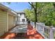 Spacious wooden deck perfect for outdoor gatherings, featuring a grill, a large table, and surrounded by lush trees at 2585 Acorn Ne Ave, Atlanta, GA 30305
