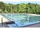 A large swimming pool with lounge chairs and lifeguard stand surrounded by mature trees at 3362 Timber Rdg, Powder Springs, GA 30127