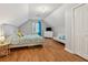 Bright bedroom featuring hardwood floors, a grey futon, and a white storage dresser at 3362 Timber Rdg, Powder Springs, GA 30127