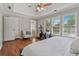 Bright bedroom featuring hardwood floors, tray ceilings, a ceiling fan, and a stationary bike at 3362 Timber Rdg, Powder Springs, GA 30127