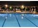 Beautifully lit community swimming pool at night with plenty of seating under a covered patio at 3362 Timber Rdg, Powder Springs, GA 30127