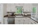Kitchen sink area with white cabinets, dark counters, and a view to the rear yard at 3362 Timber Rdg, Powder Springs, GA 30127
