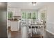Bright eat-in kitchen features white cabinets, dark counters, and a dining area with a large window view to the deck at 3362 Timber Rdg, Powder Springs, GA 30127