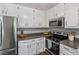 Kitchen features bright white cabinets, stainless appliances, and dark countertops at 3362 Timber Rdg, Powder Springs, GA 30127