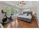 Main bedroom with hard wood floors, a tray ceiling, and lots of light from the wall of windows at 3362 Timber Rdg, Powder Springs, GA 30127