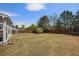 The large backyard offers green grass, an outdoor seating area, and a wood fence at 6150 Birchfield Trl, Cumming, GA 30041