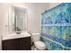 Bathroom features a vanity with a dark wood cabinet, toilet, and ornate blue patterned shower curtain at 6150 Birchfield Trl, Cumming, GA 30041