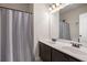 Bathroom boasts a double sink vanity, modern fixtures, and a polka dot patterned shower curtain at 6150 Birchfield Trl, Cumming, GA 30041