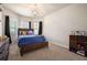 This bedroom features a wooden framed bed with storage underneath and two windows with dark curtains at 6150 Birchfield Trl, Cumming, GA 30041