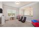 Open concept bonus room with window with blinds, a hanging light fixture, and gaming chairs at 6150 Birchfield Trl, Cumming, GA 30041