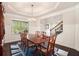 Elegant dining room featuring wainscoting, a chandelier, and a glimpse into the foyer, ideal for Gathering gatherings at 6150 Birchfield Trl, Cumming, GA 30041