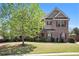 Attractive two-story brick home featuring a well-kept lawn and mature trees, offering a serene and picturesque setting at 6150 Birchfield Trl, Cumming, GA 30041
