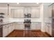 Elegant kitchen featuring stainless steel appliances and sleek white cabinetry at 6150 Birchfield Trl, Cumming, GA 30041