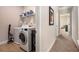 Bright laundry room featuring a modern washer and dryer set, storage shelving, and tiled flooring at 6150 Birchfield Trl, Cumming, GA 30041