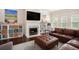 Comfortable living room featuring a fireplace and a plush brown leather sofa at 6150 Birchfield Trl, Cumming, GA 30041