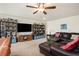 Relaxing living room with a leather sectional, ceiling fan, and ample shelving for storage and décor at 6150 Birchfield Trl, Cumming, GA 30041