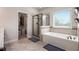 Bright main bathroom with soaking tub, tiled shower, and large window with blinds at 6150 Birchfield Trl, Cumming, GA 30041