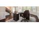 Bright office space with hardwood floors, large desk, and comfortable seating, providing an ideal work environment at 6150 Birchfield Trl, Cumming, GA 30041