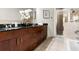 Bathroom featuring double sink vanity with granite countertops, tile floors, and glass-enclosed shower at 711 Cosmopolitan Ne Dr # 347, Atlanta, GA 30324