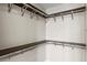 Walk-in closet featuring dark wood shelving and chrome support bars for ample storage at 711 Cosmopolitan Ne Dr # 347, Atlanta, GA 30324