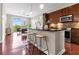 Modern kitchen with dark cabinets, stainless appliances, and an island with barstool seating that opens to living area at 711 Cosmopolitan Ne Dr # 347, Atlanta, GA 30324