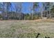 Spacious backyard with a wooded area providing privacy and a fenced perimeter at 90 Ashford Dr, Oxford, GA 30054