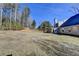Large, grassy backyard with a view of the house and screened-in porch addition at 90 Ashford Dr, Oxford, GA 30054