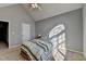 Bedroom with vaulted ceiling and natural light coming through arched window, with a bed and door at 90 Ashford Dr, Oxford, GA 30054
