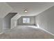 Large, carpeted bonus room with natural light from a double-hung window at 90 Ashford Dr, Oxford, GA 30054