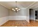 Bright dining room features hardwood floors, decorative wainscoting, fresh paint, and classic chandelier at 90 Ashford Dr, Oxford, GA 30054