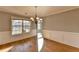Bright dining room with hardwood floors, wainscoting and a modern chandelier at 90 Ashford Dr, Oxford, GA 30054