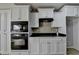 Kitchen with white cabinets, black appliances, and plenty of counter space at 90 Ashford Dr, Oxford, GA 30054