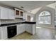 Bright kitchen features white cabinets, black appliances, and an island overlooking the breakfast nook at 90 Ashford Dr, Oxford, GA 30054