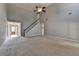 Open living room with tall ceilings, staircase, neutral carpet, and view of entry at 90 Ashford Dr, Oxford, GA 30054