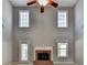 Cozy living room with fireplace, ceiling fan, tall ceilings, and bright windows at 90 Ashford Dr, Oxford, GA 30054