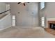 Large living room with fireplace, staircase, tall ceilings, and neutral carpet at 90 Ashford Dr, Oxford, GA 30054