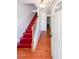 Home entryway featuring hardwood floors, a staircase with red steps, and natural light from the door at 1294 Park Pass Way, Suwanee, GA 30024