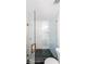 Modern shower featuring glass doors, elegant white marble-style walls, and striking black honeycomb-patterned floor tiles at 1294 Park Pass Way, Suwanee, GA 30024
