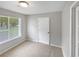 Bright bedroom with neutral carpet, a window with blinds, and a standard closet door at 245 Adena W Ln, Atlanta, GA 30349
