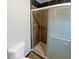 Tiled shower with glass door, complemented by black trim and a neutral-colored toilet at 245 Adena W Ln, Atlanta, GA 30349