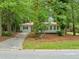 Charming single-story home with a metal roof surrounded by mature trees and lush landscaping at 3452 Ridgecrest Dr, Powder Springs, GA 30127